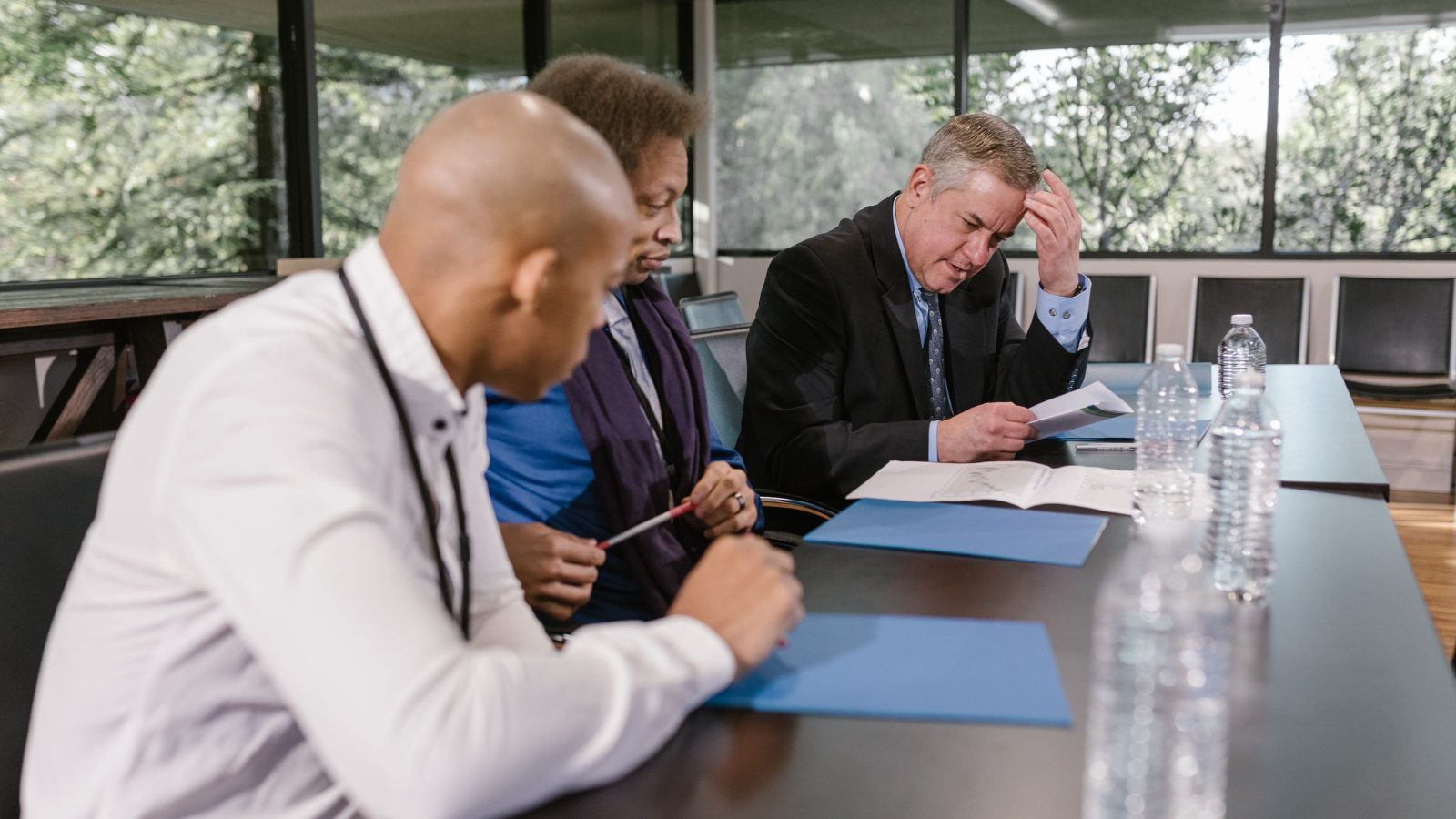 Executives working through a decision together at a meeting table.