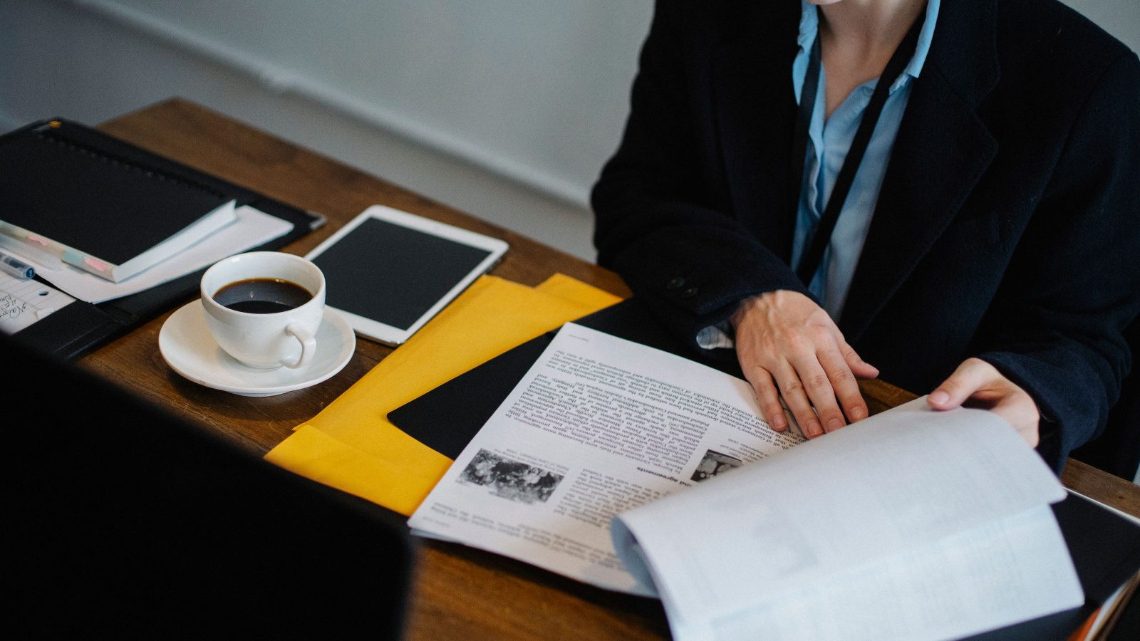 Two professionals reviewing written business proposals at a desk.