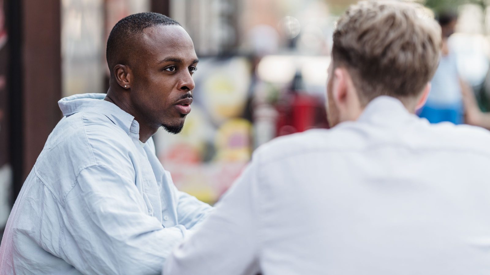 Two professionals working through a question across a meeting table.